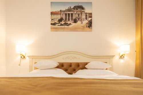 ein Schlafzimmer mit einem Bett mit einem Bild an der Wand in der Unterkunft Casa Doseanu in Oradea