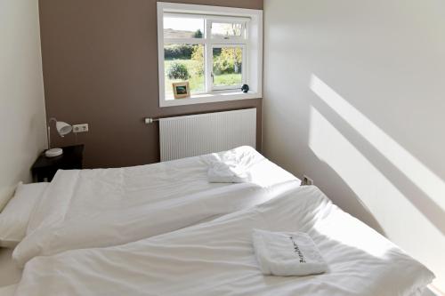a white bed in a room with a window at Breidamyri Farm Apartments in Laugar