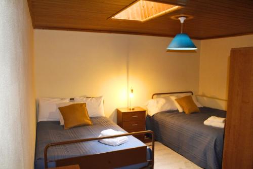 a bedroom with two beds and a blue light at Casa Castro - Refúgio Rural em Fonte Arcada, Silêncio e Conforto in Fonte Arcada