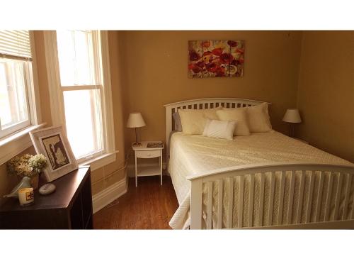 a bedroom with a bed and a nightstand and two windows at The B in Louisville