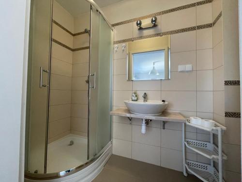 een badkamer met een wastafel en een douche bij pensjonat KAJA 200 metrów od morza in Międzyzdroje
