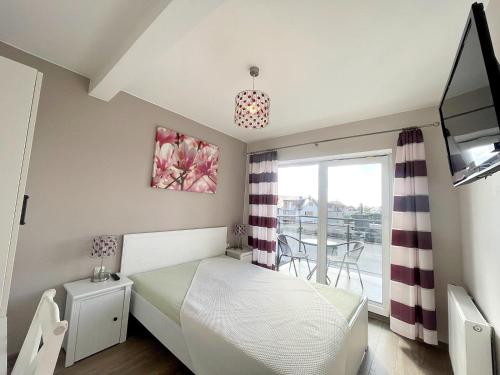 een kleine slaapkamer met een bed en een balkon bij pensjonat KAJA 200 metrów od morza in Międzyzdroje