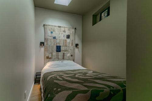 a small bedroom with a bed in a room at Le Bompart - Petite maison design et confortable proche centre in Clermont-Ferrand