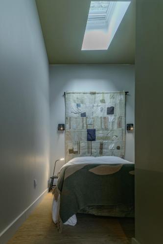 a bedroom with a bed and a skylight at Le Bompart - Petite maison design et confortable proche centre in Clermont-Ferrand