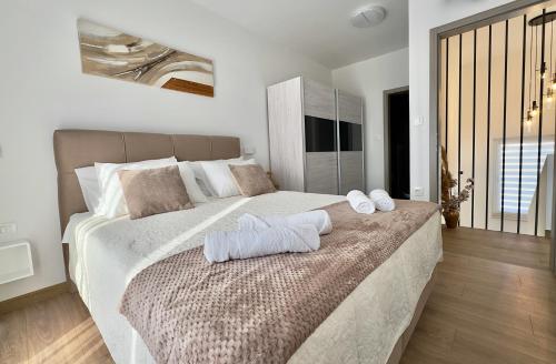 een slaapkamer met een groot bed met handdoeken erop bij Vila Gaspar in Dražice
