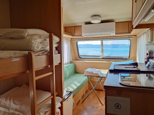 a small room with a bunk bed and a desk at 直島町ふるさと海の家 つつじ荘 Seaside Stay Tsutsuji-so in Naoshima