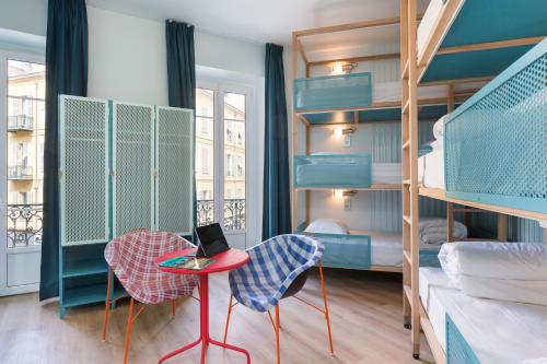 um quarto com beliches e uma mesa com um computador portátil em Hostel Ozz Nice em Nice