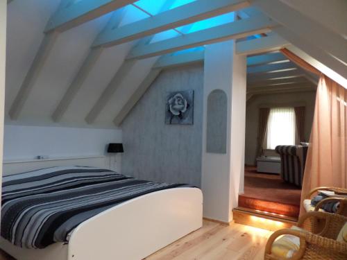 ein Schlafzimmer mit einem Bett mit blauer Decke in der Unterkunft B&B Huize Cossee in Gasselte