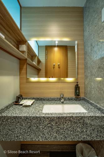 a bathroom with a sink and a large mirror at Siloso Beach Resort - Sentosa in Singapore
