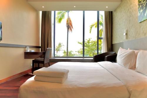 新加坡Siloso Beach Resort - Sentosa的一间酒店房间，配有一张大床和一扇窗户