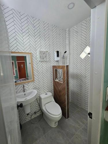 a bathroom with a toilet and a sink at คุณเก้า รีสอร์ท in Non Sa-at