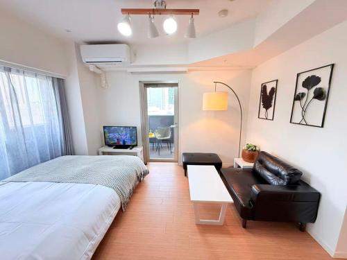 a bedroom with a bed and a couch and a television at Cozy APT Stay in Center Tokyo -SHIBUYA in Tokyo