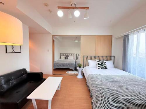 a bedroom with two beds and a couch and a mirror at Cozy APT Stay in Center Tokyo -SHIBUYA in Tokyo