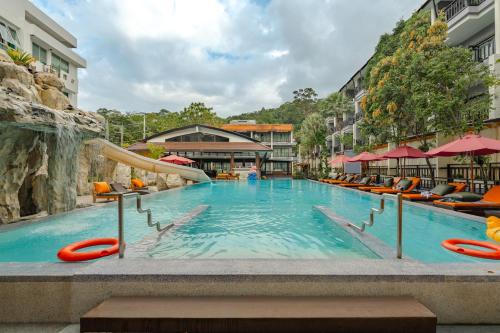 a swimming pool with a slide in a resort at Phuvaree Resort in Patong Beach