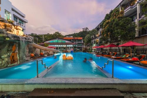 een zwembad op een resort met mensen erin bij Phuvaree Resort in Patong Beach