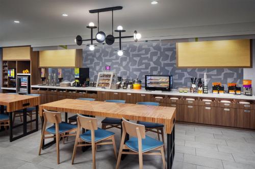 une cuisine avec une grande table et des chaises en bois dans l'établissement Home2 Suites By Hilton Memphis Downtown, à Memphis