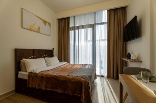 a hotel room with a bed and a large window at Roomook Cozy studio in Dubai
