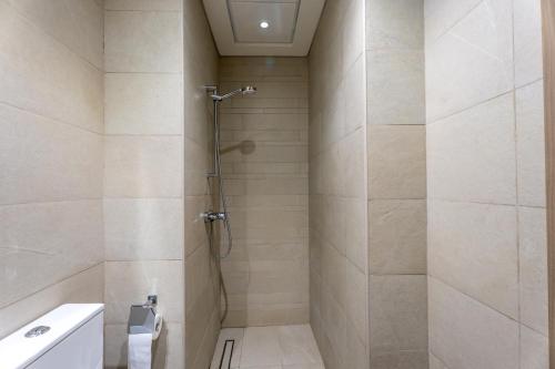 a bathroom with a shower with a toilet and a sink at Roomook Cozy studio in Dubai