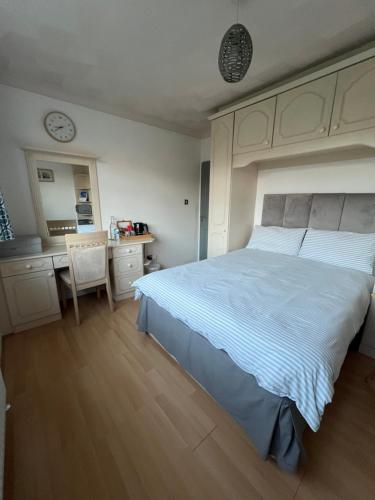 a bedroom with a bed and a desk and a kitchen at The Bungalow by SJP - Double Room in Kettering