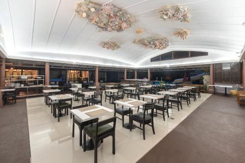 a dining area with tables and chairs in a restaurant at Phuvaree Resort in Patong Beach