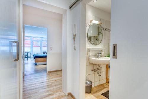 a bathroom with a sink and a mirror at Alte Teestube Schmidt 58 in Norderney