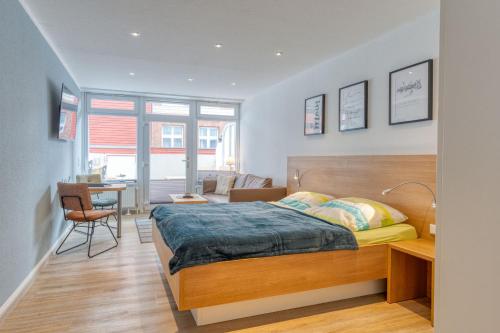 a bedroom with a bed and a desk in a room at Alte Teestube Schmidt 58 in Norderney