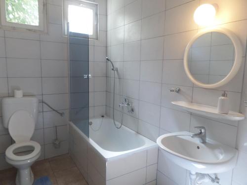 a white bathroom with a toilet and a sink at River Apartment in Mostar