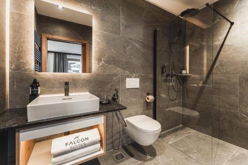 a bathroom with a sink and a toilet and a shower at Falcon Suites Pure - Summercard included in Kaprun