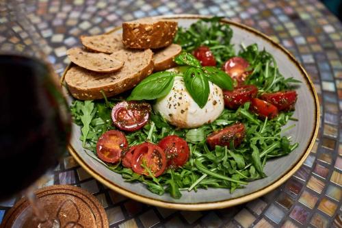 a plate of food with a salad with bread and tomatoes at Cocoon Sendlinger Tor in Munich