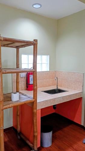 a kitchen with a sink and a shelf at Suki Beach Resort Beachfront Cottage in Santa Magdalena