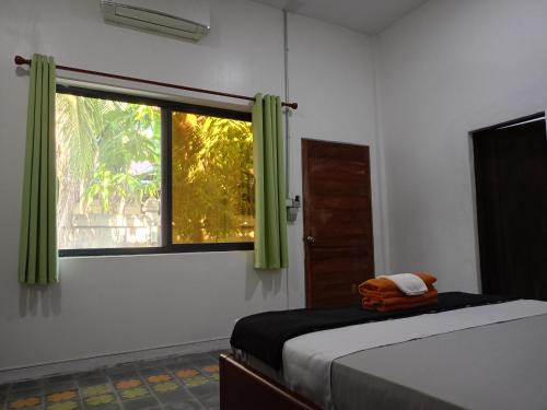 a bedroom with a bed and a window with green curtains at Passport Villa in Siem Reap