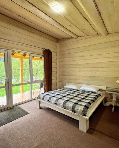 a bedroom with a bed in a wooden room at Cozy Rest House in Verkhovyna