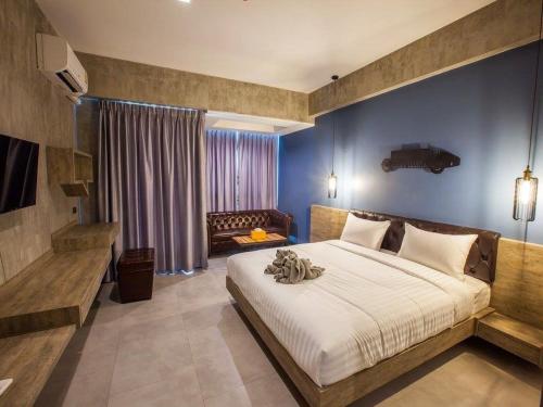 a bedroom with a large bed with a blue wall at Loft Mania Boutique Hotel in Chumphon