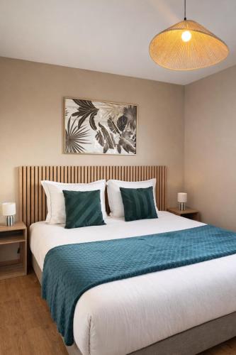 a bedroom with a large bed with green and white pillows at Maison entiere jacuzzi reception ouverte 7 7j et 24 24h in Ambarès-et-Lagrave