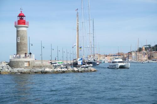 a red and white lighthouse in a harbor with boats at Villa Perle De La Mer in Saint-Aygulf
