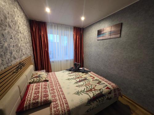 een slaapkamer met een bed en een raam bij Green- Guest Apartment- Tapa in Taps