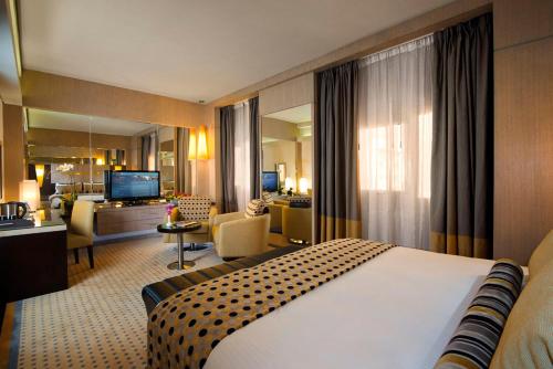 a hotel room with a bed and a living room at TIME Grand Plaza Hotel, Dubai Airport in Dubai