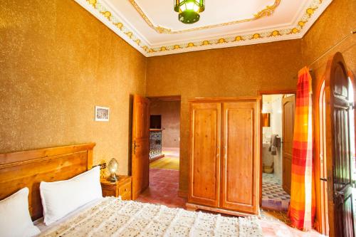 a bedroom with a bed and a room with a ceiling at Riad Soleil du Monde in Zagora