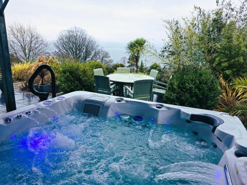 a hot tub in a backyard with a table at Viewpoint Villa - Luxury 4 Bedroom villa with elevated views in Rothesay
