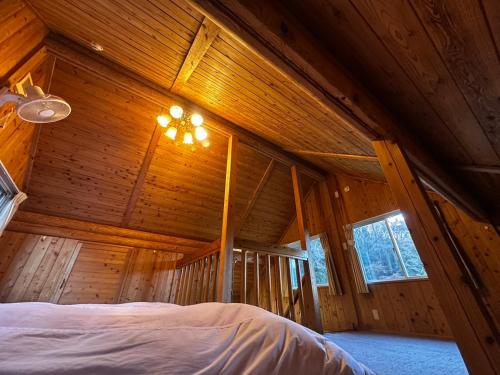 a bedroom in a wooden cabin with a bed at コテージ杏庵 Cottage Anzuan in Minamioguni