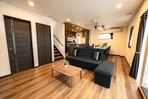 a living room with a couch and a table at Guest House TEINE Nisimiyanosawa 41 最大11名滞在 無料駐車場2台完備 TEINE Ski Resort車で15分 in Sapporo
