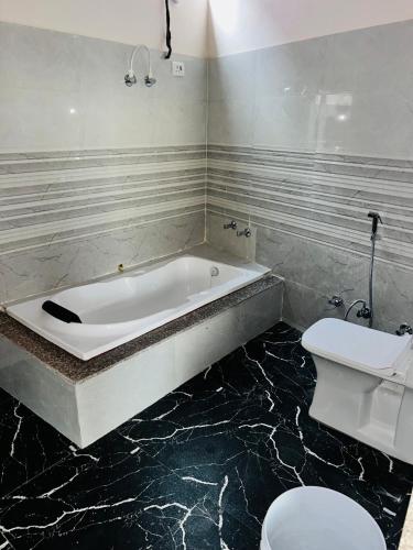 a bathroom with a bath tub and a toilet at New hotel Arjun place, Reengus in Rīngas