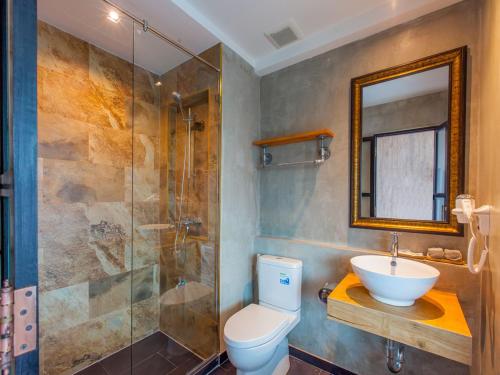 a bathroom with a toilet and a shower and a sink at Loft Mania Boutique Hotel in Chumphon