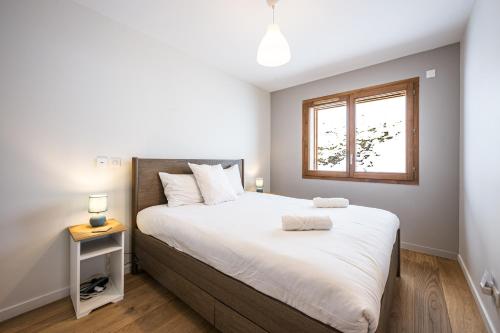 a bedroom with a large bed and a window at Chalet Angelus C201 in Saint-Jean-de-Sixt