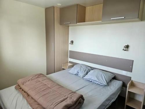 ein kleines Schlafzimmer mit einem Bett mit einer Decke darauf in der Unterkunft Camping 4 étoiles - Piscine - ccbegca in Créach-Guennou