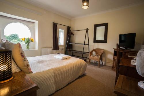 a bedroom with a bed and a tv and a chair at The Coach House in Bristol