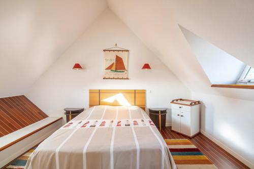 a bedroom with a large bed in a attic at Le Nautic - 5min à pied de la plage in Bénodet