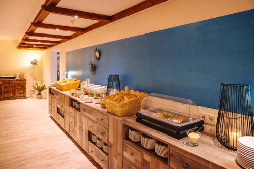 eine Buffetlinie mit Essen an einer blauen Wand in der Unterkunft Bernsteinsee Hotel&Ferien in Sassenburg