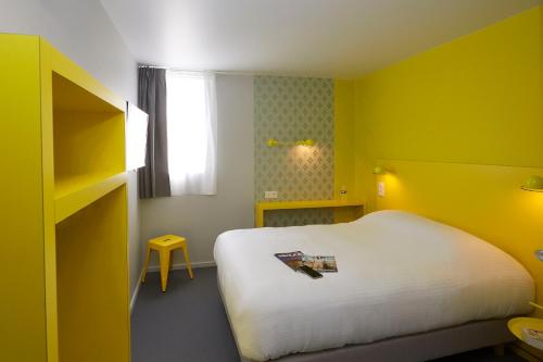 a bedroom with a white bed and yellow walls at Coto Hotel in Beaune