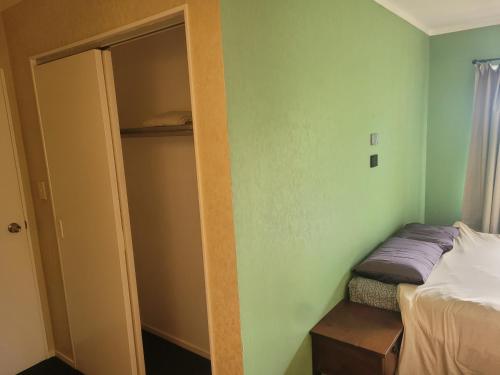 een kleine slaapkamer met een bed en een kast bij Villa in Bellevue in Tauranga